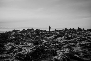 İzlanda dağlarının ovasında duran genç adamın güzel panoramik manzarası