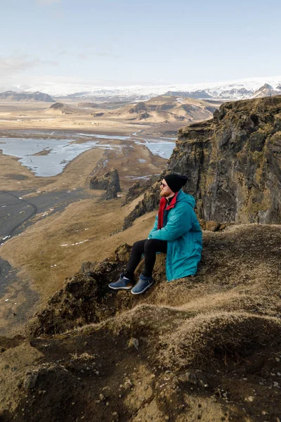 Cute Young Man Sitting Cliff Black Sand Beach Mountains View — Stockfoto