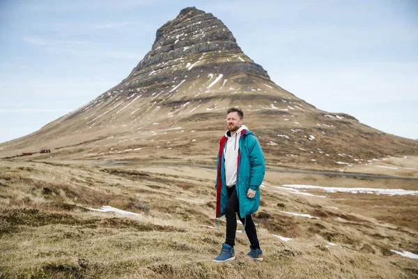 Jóképű Fiatalember Kék Kabátban Sétál Fűpályán Izland Hegyei Előtt — Stock Fotó