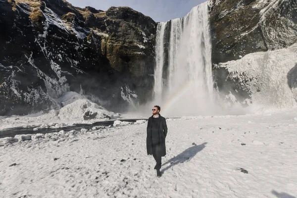 Knappe Man Zonnebril Staan Waterval Ijsland Bergen Achtergrond — Stockfoto