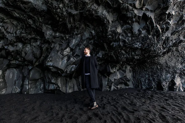 Pohledný Mladý Muž Pózuje Blízkosti Velké Černé Jeskyně Černém Písku — Stock fotografie