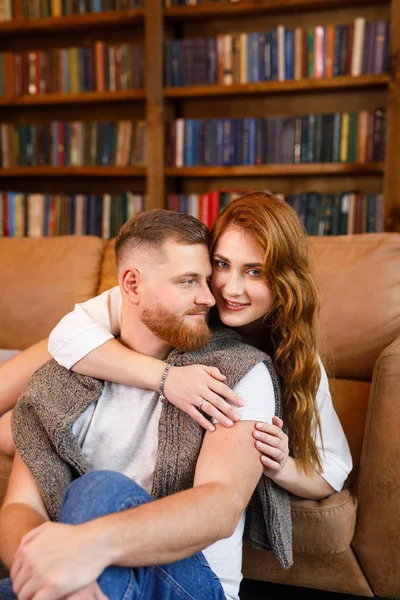 Joven Hermosa Pareja Sentada Cama Fondo Biblioteca Los Libros Apartamento — Foto de Stock