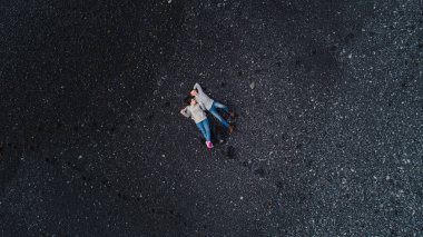 Genç ve güzel bir çift İzlanda 'daki Atlantik Okyanusu' nun kıyısındaki bir kumsalda uzanır.