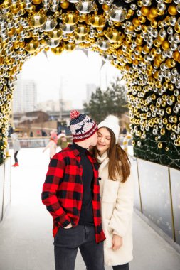 Şehir buz pateni sahasında öpüşen genç aşıklar