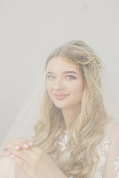 白い部屋に花束を持つ若い美しいブロンドの花嫁の肖像画 — ストック写真