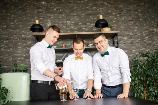 白いシャツの男3人がロフトのアパートでウィスキーを飲む — ストック写真