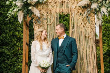 Güzel bir boho tarzı düğün töreni. Güzel elbiseli gelin ve klasik takım elbiseli damat.