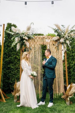 Güzel bir boho tarzı düğün töreni. Güzel elbiseli gelin ve klasik takım elbiseli damat.