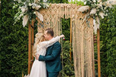 Güzel bir boho tarzı düğün töreni. Güzel elbiseli gelin ve klasik takım elbiseli damat.