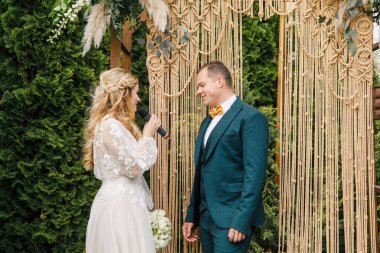 Güzel bir boho tarzı düğün töreni. Güzel elbiseli gelin ve klasik takım elbiseli damat.