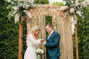 Güzel bir boho tarzı düğün töreni. Güzel elbiseli gelin ve klasik takım elbiseli damat.