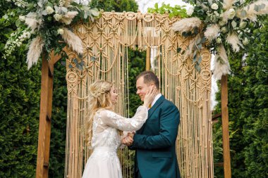 Güzel bir boho tarzı düğün töreni. Güzel elbiseli gelin ve klasik takım elbiseli damat.