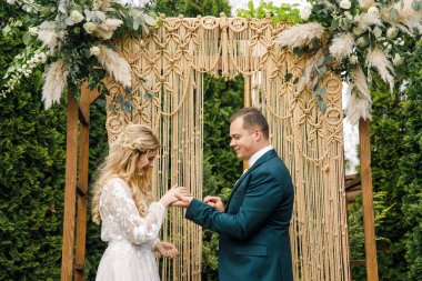 Güzel bir boho tarzı düğün töreni. Güzel elbiseli gelin ve klasik takım elbiseli damat.