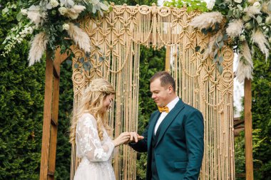 Güzel bir boho tarzı düğün töreni. Güzel elbiseli gelin ve klasik takım elbiseli damat.