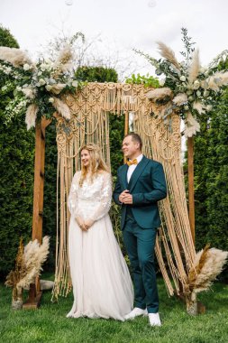 Güzel bir boho tarzı düğün töreni. Güzel elbiseli gelin ve klasik takım elbiseli damat.