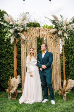Güzel bir boho tarzı düğün töreni. Güzel elbiseli gelin ve klasik takım elbiseli damat.
