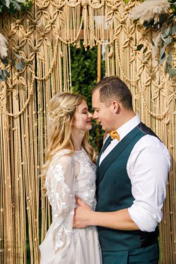 Güzel bir boho tarzı düğün töreni. Güzel elbiseli gelin ve klasik takım elbiseli damat.