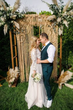 Güzel bir boho tarzı düğün töreni. Güzel elbiseli gelin ve klasik takım elbiseli damat.