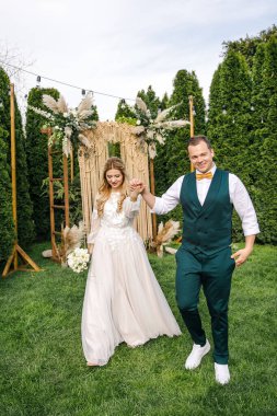 Güzel bir boho tarzı düğün töreni. Güzel elbiseli gelin ve klasik takım elbiseli damat.