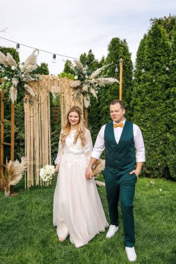 Güzel bir boho tarzı düğün töreni. Güzel elbiseli gelin ve klasik takım elbiseli damat.