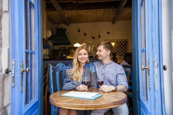 青い扉の近くのレストランで食事をした青い服を着たカップルが — ストック写真
