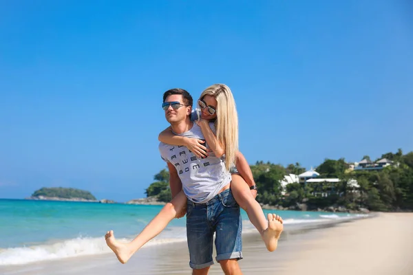 Junges schönes glückliches Paar, das Spaß am Strand hat. Huckepack-Fahrten. positive menschliche Emotionen, Gefühle. Liebesgeschichte — Stockfoto