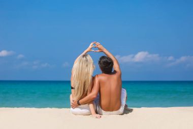 Sahilde oturan ve zevk güzel Deniz Manzaralı, yan görünüm, birlikte vakit, yaz tatil kavramı Romantik Çift