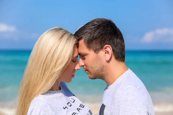 Retrato de close-up ao ar livre de casal muito jovem apaixonado se divertindo com o tempo quente e se sentindo feliz juntos na ilha tropical. Posando e abraços sozinhos na praia . — Fotografia de Stock