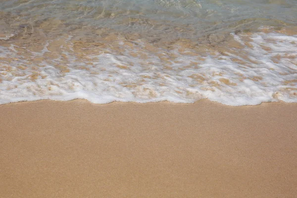 Sanfte Welle des blauen Ozeans am Sandstrand. Hintergrund. — Stockfoto