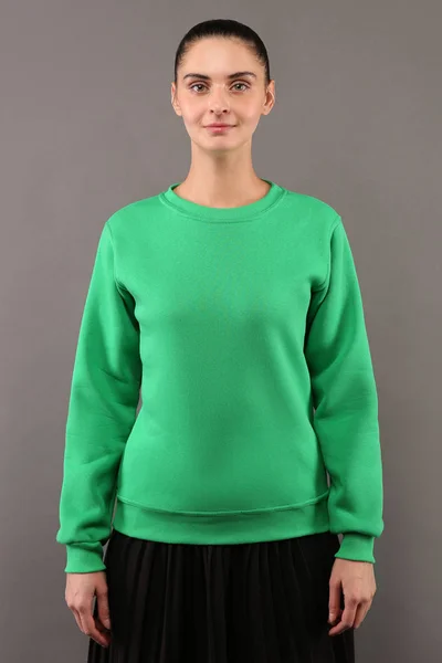 Hipster młoda dziewczyna ubrana w puste lipa Zielona bawełniana Bluza z kopia miejsce na Twój projekt lub logo, makiety ltemplate Damska bluza z kapturem, szare ściany w tle — Zdjęcie stockowe