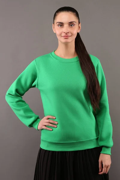 Hipster młoda dziewczyna ubrana w puste lipa Zielona bawełniana Bluza z kopia miejsce na Twój projekt lub logo, makiety ltemplate Damska bluza z kapturem, szare ściany w tle — Zdjęcie stockowe