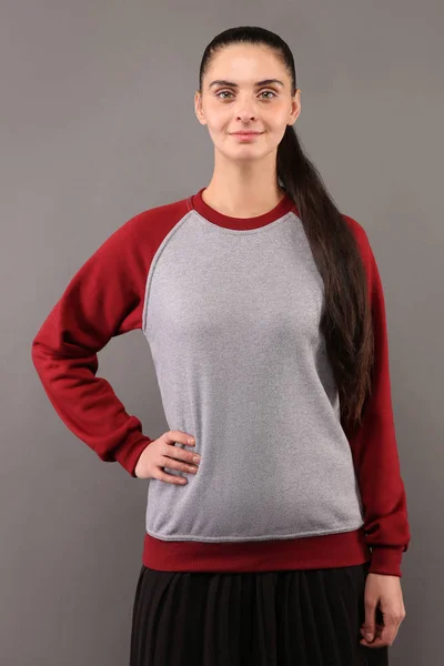 Young hipster girl wearing blank grey and burgundy cotton sweatshirt with crew neck and raglan sleeves with copy space for your design or logo, mock-up of ltemplate womens hoodie
