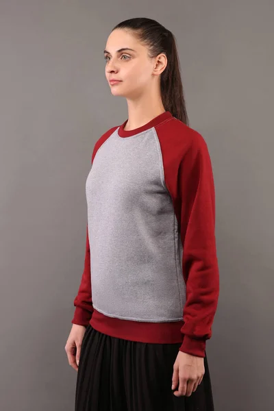 Young hipster girl wearing blank grey and burgundy cotton sweatshirt with crew neck and raglan sleeves with copy space for your design or logo, mock-up of ltemplate womens hoodie — Stock Photo, Image