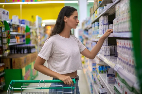 Hermosa mujer joven de compras en un supermercado de comestibles — Foto de Stock