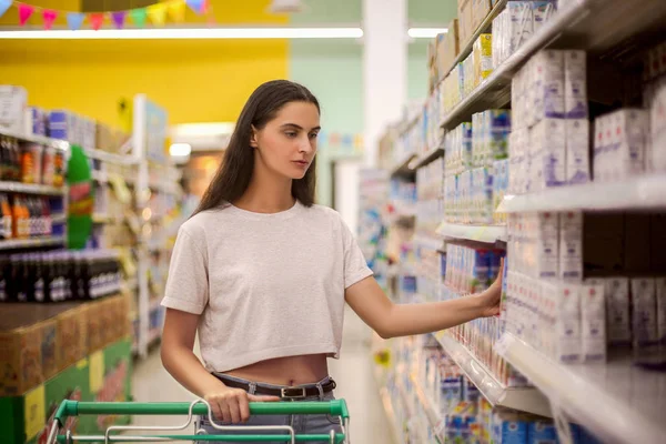 Hermosa mujer joven de compras en un supermercado de comestibles — Foto de Stock