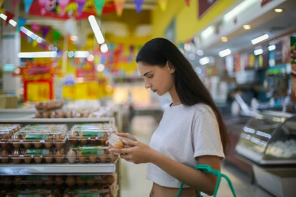 Venta, compras, consumismo y concepto de personas - mujer con canasta de alimentos en la tienda de comestibles o supermercado — Foto de Stock