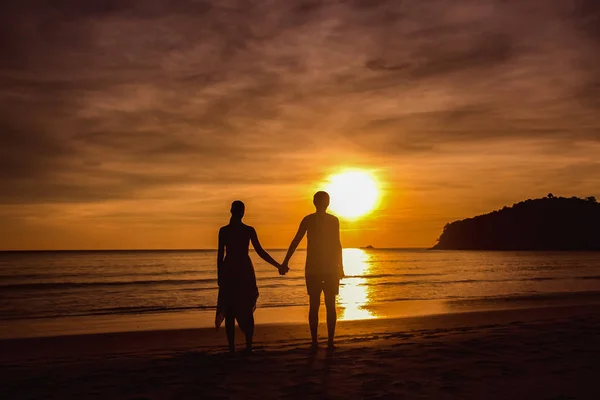 Una pareja cogida de la mano durante un atardecer increíble. Pareja amorosa en el estanque al atardecer abrazo — Foto de Stock