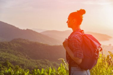 Hippi kız günbatımı sisli dağ tepe üzerinde zevk sırt çantası ile. Arka plan görünüm mockup üzerinde turist gezgin. Tonda, Instagram filtre