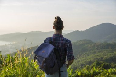 Hippi kız en yüksek dağında gün batımı zevk sırt çantası ile. Arka plan Vadisi manzara görünümü mockup üzerinde turist Gezgin.