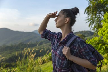 Hippi kız en yüksek dağında gün batımı zevk sırt çantası ile. Arka plan Vadisi manzara görünümü mockup üzerinde turist Gezgin.