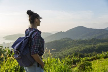 Hippi kız en yüksek dağında gün batımı zevk sırt çantası ile. Arka plan Vadisi manzara görünümü mockup üzerinde turist Gezgin.