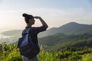 Hippi kız en yüksek dağında gün batımı zevk sırt çantası ile. Arka plan Vadisi manzara görünümü mockup üzerinde turist Gezgin.