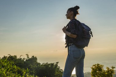 Hippi kız en yüksek dağında gün batımı zevk sırt çantası ile. Arka plan Vadisi manzara görünümü mockup üzerinde turist Gezgin.