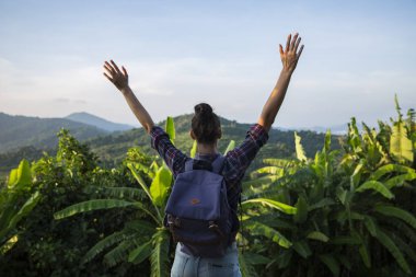 Hippi kız en yüksek dağında gün batımı zevk sırt çantası ile. Arka plan Vadisi manzara görünümü mockup üzerinde turist Gezgin.