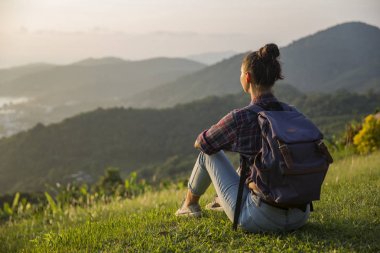 Hippi kız en yüksek dağında gün batımı zevk sırt çantası ile. Arka plan Vadisi manzara görünümü mockup üzerinde turist Gezgin.