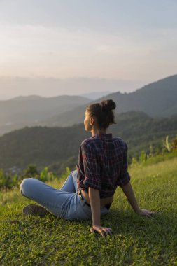 Hippi kız en yüksek dağında gün batımı zevk sırt çantası ile. Arka plan Vadisi manzara görünümü mockup üzerinde turist Gezgin.