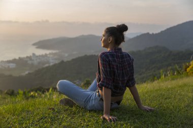 Hippi kız en yüksek dağında gün batımı zevk sırt çantası ile. Arka plan Vadisi manzara görünümü mockup üzerinde turist Gezgin.
