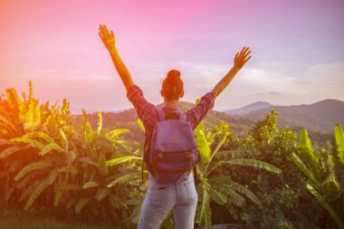 Hippi kız en yüksek dağında gün batımı zevk sırt çantası ile. Arka plan Vadisi manzara görünümü mockup üzerinde turist gezgin. Tonda. Instagram filtre