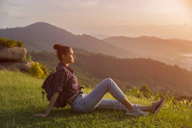 Hippi kız en yüksek dağında gün batımı zevk sırt çantası ile. Arka plan Vadisi manzara görünümü mockup üzerinde turist gezgin. Tonda. Instagram filtre