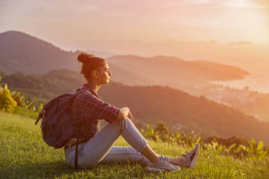 Hippi kız en yüksek dağında gün batımı zevk sırt çantası ile. Arka plan Vadisi manzara görünümü mockup üzerinde turist gezgin. Tonda. Instagram filtre